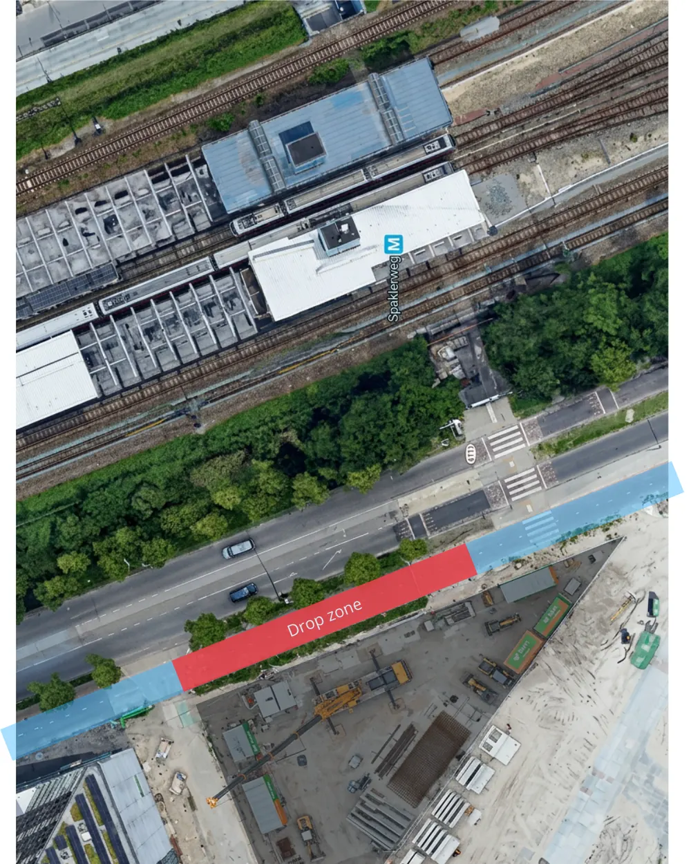 Overhead site plan with the crane drop zone marked in red across the blue cycle path and footpath, with Spaklerweg metro station north of the site.