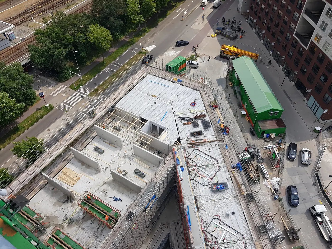 Aerial photograph taken from the tower crane, looking down on the construction site. The cycle path and road run directly along the edge of the works.